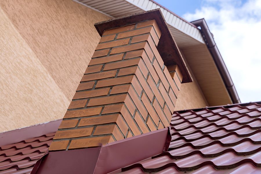 Redish metal roof shingles with matching shingle flashing color