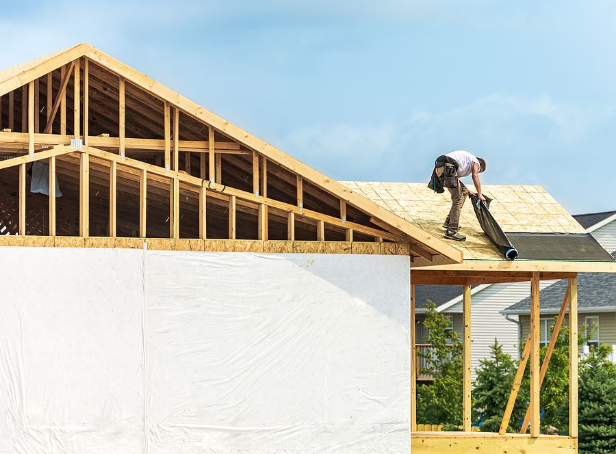 Stock image of roofing underlayment being installed on new residential home